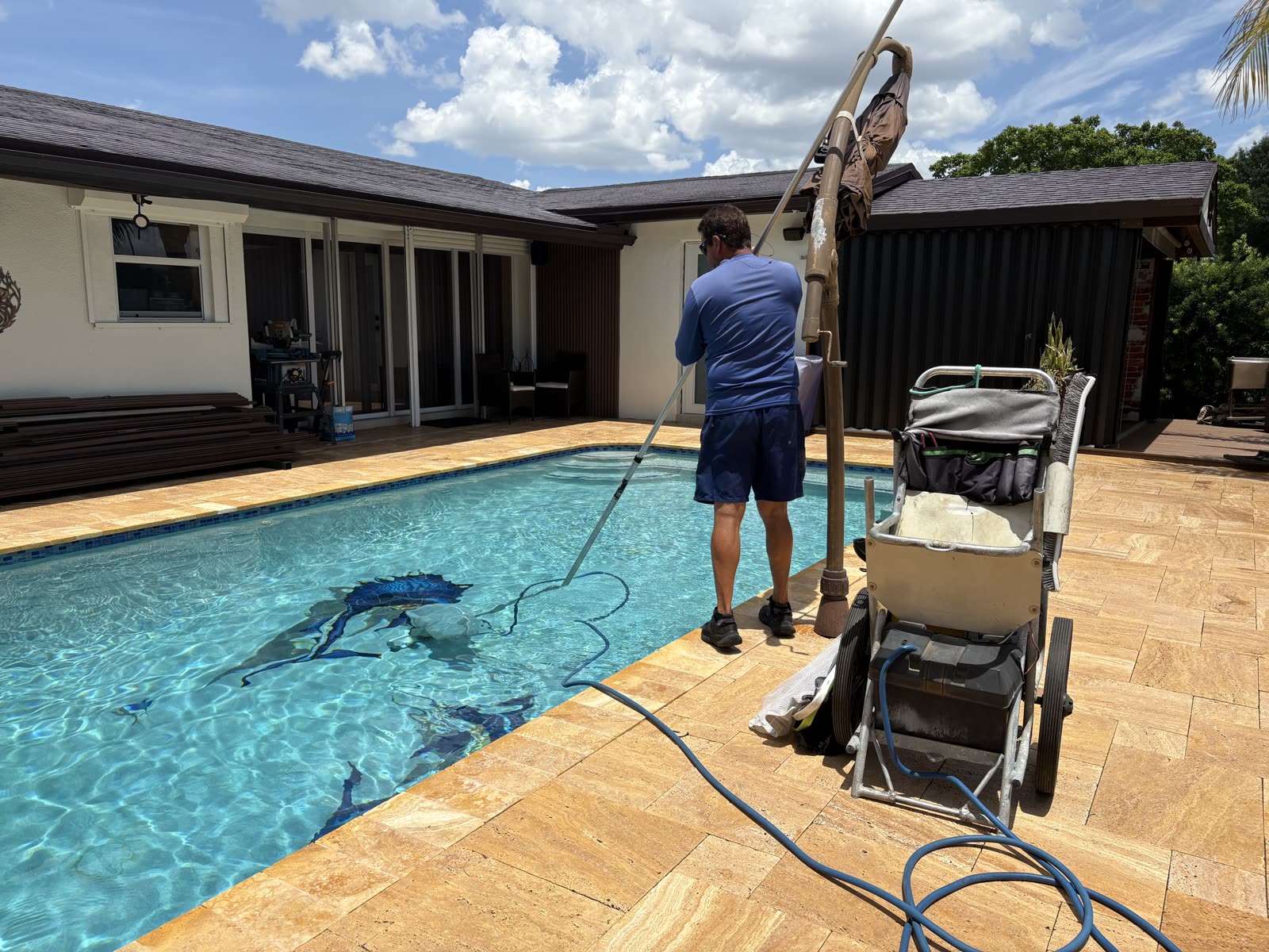 Javier surface-cleaning a client's pool in Broward